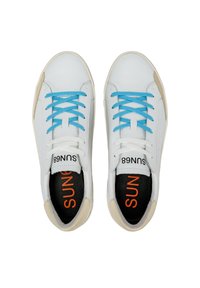 Sneakers bianchi in pelle con lacci blu, suole nere con testo arancione e dettagli beige sulla suola. Design atletico classico.