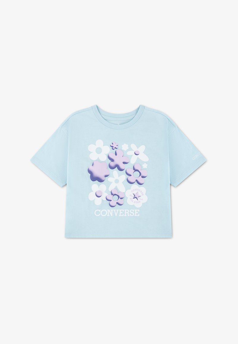 T-shirt à manches courtes bleu clair avec des motifs floraux 3D blancs et violets et le texte "CONVERSE" en dessous du design.
