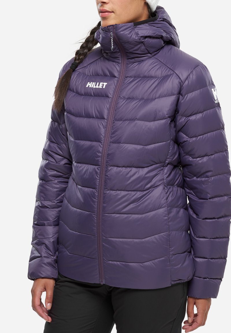 Veste matelassée violette avec col montant et fermeture éclair intégrale. Présente le logo de la marque sur la poitrine et des poignets élastiques pour un ajustement confortable.