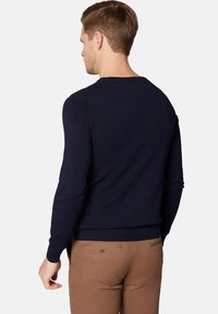 Granatowy dzianinowy sweter z prążkowanym, okrągłym dekoltem i długimi rękawami, posiada dopasowany dół oraz gładką teksturę.