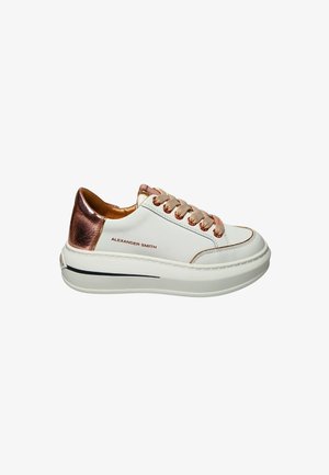 Sneaker bianca in pelle con tacco e dettagli metallici bronzo, punta rotonda, lacci beige e una spessa suola in gomma bianca con una striscia blu navy.