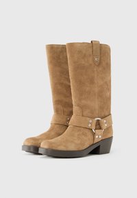 Par čevljev iz rjave semiša do sredine meč, z nizkimi petami, okrasnimi trakovi, srebrnimi zakovicami in zanko za poteg na zgornjem robu.