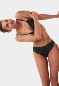 Zwart lingeriesetje met een driehoekige beha met dunne bandjes en bijpassende bikini briefs met kantafwerking, met een zachte stof en delicate details.