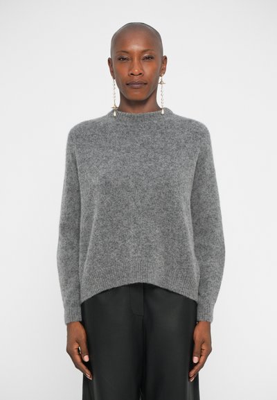 Gray knitted sweater with a high neckline, soft texture, and ribbed hem. Paired with black leather pants, featuring notable drop sleeves.