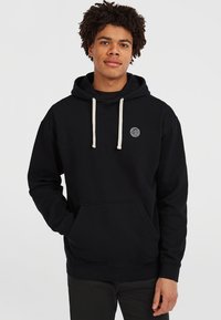 Haut à capuche noir en coton, avec une poche kangourou à l'avant, une capuche à cordon crème et un logo circulaire sur la poitrine.