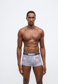 Boxeralsó tengerészkék derékpánttal, csíkos mintázattal és élénk, többszínű grafikai díszítéssel. Rugalmas anyagból készült a kényelem érdekében.