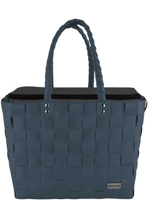 Woven tote bag in dark blue with a sturdy black top. Features braided handles, a zippered closure, and silver-tone hardware accents.