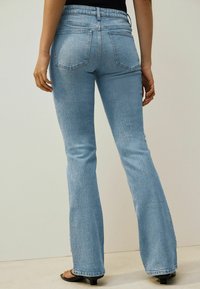 Lichtblauwe flared jeans van denim, met een middelhoge tailleband, twee achterzakken en een licht vervaagde textuur.