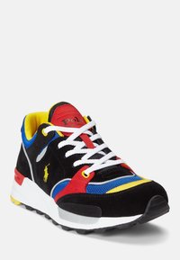 Mångfärgad sneaker med svart mocka, röda, gula och blå mesh-detaljer, vita snören och en texturerad gummisula.