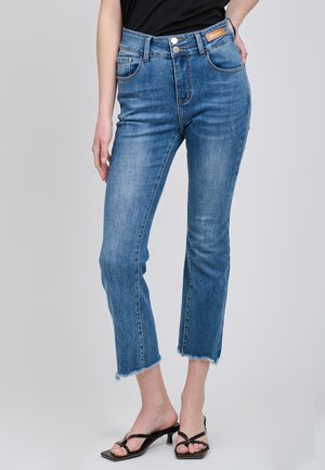 Jeans azzurri chiari a vita alta con un leggero effetto sbiadito, orlo corto e bordi sfrangiati. Presentano due tasche anteriori e due tasche posteriori.