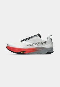Baskets de course blanches avec accents rouges, tige en mesh, surface texturée, lacets noirs, semelle grise et marquage Vibram sur la semelle extérieure.
