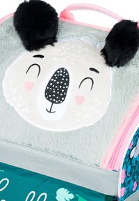 Měkký šedý plyšový batoh s medvědím obličejem, černými ušima, vyšitými detaily a barevným květinovým vzorem na dně.