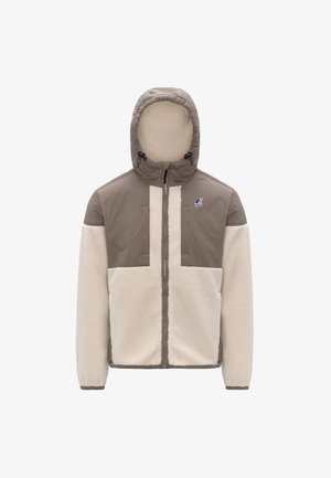 Giacca foderata in pile con una combinazione di colori beige e crema. Presenta un cappuccio, chiusura a zip e un design con pannelli distintivi. Include un dettaglio del logo.