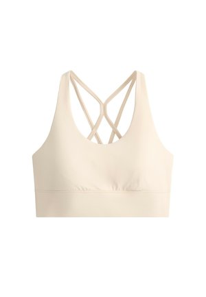 Lyse beige sports-bh med tynde dobbelte krydsede stropper på ryggen og en bred elastik i bunden.