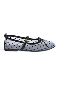 Ballerines transparentes à pois avec bord noir, une sangle avec fermeture à boucle et une semelle en caoutchouc noir flexible.