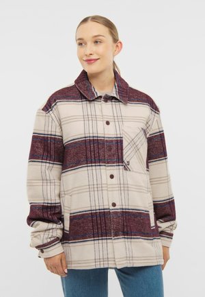 Beige Langarmhemdjacke mit kariertem Muster in Maronen- und Blautönen, Knopfverschluss vorne und Brusttasche mit Klappe. Aus weichem, warmem Material.