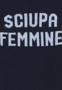 Tessuto lavorato a maglia blu navy con la scritta "SCIU SPA FEMMINE" in bianco contrastante, con una superficie strutturata e lettere a blocchi audaci.