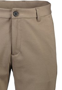Beige broek met een gladde textuur, voorzien van een knoopsluiting en een elegant ontwerp. Zichtbare stiksels en zakken nabij de tailleband.