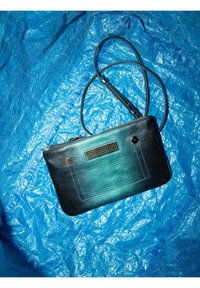 Clutch tas met een gradient teal en zwarte textuur, voorzien van een ritssluiting en twee ronde metalen accenten.