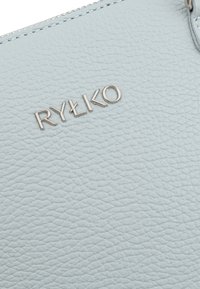 Portafoglio in pelle blu chiaro e texture con logo "RYŁKO" in argento. Presenta un bordo della cerniera liscio e dettagli di cucitura minimi.