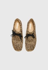 Leopard print casual shoes with a soft texture, black laces, and a rounded toe design. Brand label visible inside.