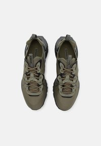 Zelené sportovní boty s texturovaným síťovaným svrškem, šedými detaily a černou gumovou podrážkou. Mají unikátní šněrovací systém a zesílenou špičku.