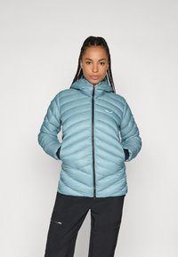 Svijetloplavi puffer jakna s chevron šavovima, zatvaranjem na zip, i kapuljačom; ima ručne džepove i mali logotip na prsima.