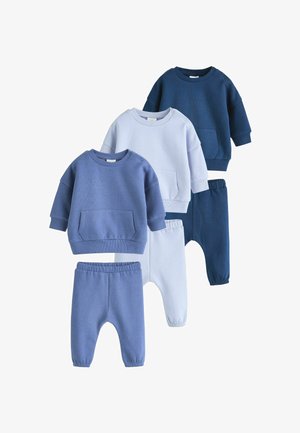 Vier sets van kinderdekens en broeken in verschillende tinten blauw. Kenmerken zijn onder andere ronde halsen, zakken en elastische taillebanden.