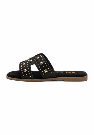 Chanclas negras con suela plana, que presentan un upper texturizado adornado con tachuelas de metal dorado en un patrón geométrico.
