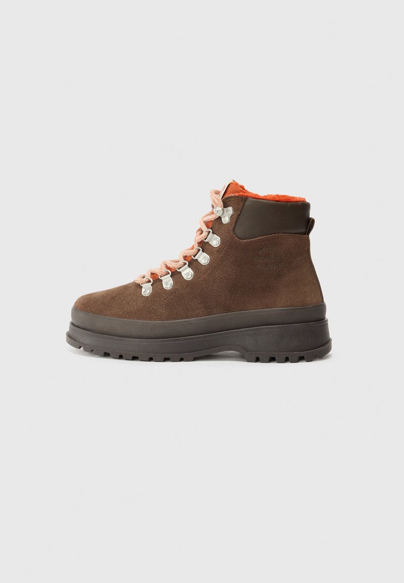 Botas de senderismo de ante marrón con forro naranja, ojales de metal plateado y cordones rosas. Suela de goma gruesa con textura para un mejor agarre.