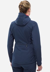Veste de sport bleu marine avec capuche, au design ajusté, texture lisse et poche zippée dans le bas du dos.