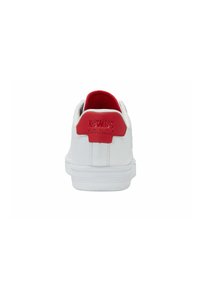 Sneaker bianca con un pannello posteriore rosso e una linguetta testurizzata. Presenta una tomaia liscia in materiale sintetico, un contrafforte del tallone rinforzato e una suola in gomma.