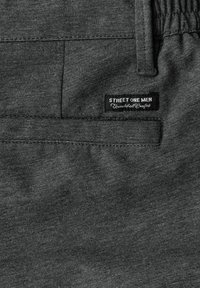 Tissu gris foncé pour pantalon homme avec poche arrière et étiquette noire portant l'inscription "STREET ONE MEN Confort Inégalé".