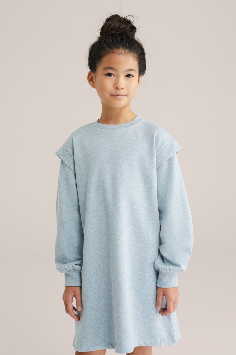 Svetlo modra obleka s kapuco iz mehkega bombaža, z dolgimi rokavi, ribastimi manšetami in okrasnimi žebljički na ramenih. Ohlapen kroj.