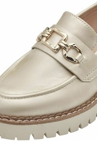 Beige Lederloafer mit einer goldenen Kettenakzent, flacher Sohle, dicker strukturierten Kante und detaillierter Naht entlang des Obermaterials und der Sohle.