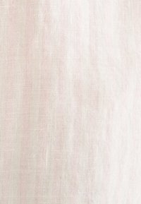 Tessuto di lino rosa chiaro con una superficie morbida e testurizzata, caratterizzato da un leggero motivo di tessitura irregolare e fibre naturali.