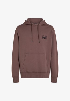 Brūns kapucis, izgatavots no mīkstas auduma, ar priekšējo kabatu, kapuci ar auklām un minimālistisku melnu grafiku ar seju, kas valkā saulesbrilles.