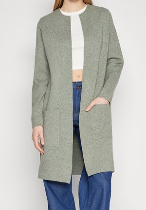 Cardigan largo verde claro hecho de un suave tejido de punto. Diseño de frente abierto con dos bolsillos frontales, cuello redondo y mangas largas.