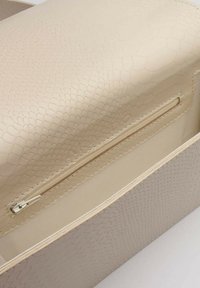 Borsa a tracolla in finta pelle di serpente color tan con superficie liscia, dotata di una tasca con zip e una forma rettangolare strutturata.