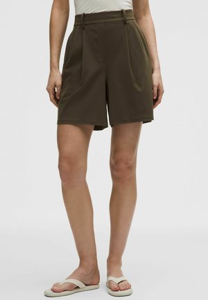 Oliven grønne shorts med skræddersyet pasform, høj talje, plisseringer og sidelommer. Fremstillet af blødt, struktureret stof. Enkel design.