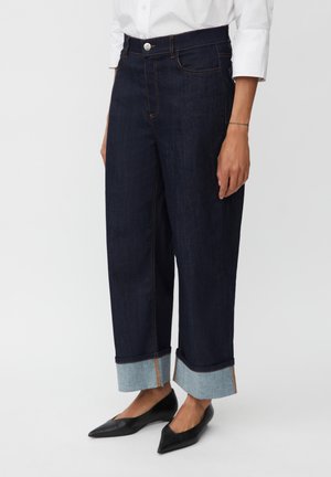 Donkerdenim jeans met een ontspannen pasvorm, opgerolde manchetten van lichter denim, met contrasterende stiksels en een sluiting met een voorste knoop.