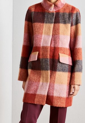 Uld ternet frakke med stort ternet mønster i røde, pink, beige og grå farver, med klaplommer og en rundet krave.