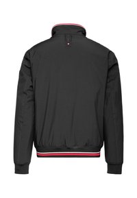 Schwarze Bomberjacke mit einem hohen Kragen, elastischen Bündchen und Saum. Verfügt über rot-weiße gestreifte Akzente entlang des Kragens und des Bunds.