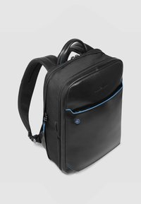 Zaino nero con una texture liscia simile alla pelle, caratterizzato da dettagli blu, doppia cerniera, spallacci imbottiti e maniglia superiore per il trasporto.