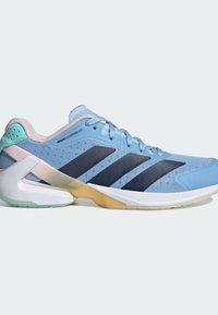 Light blue athletic shoe with mesh upper, navy stripes, and textured accents. Features a white sole and a unique, shaped heel design.
