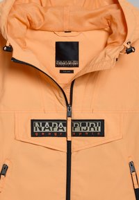 Lichtoranje waterdichte jas met zwarte rits, mesh voering, voorzakken met rits en een logo-patch met "NAPAPIJRI geographic."