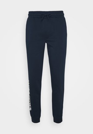 Joggers azul marino hechos de una suave mezcla de algodón, con una cintura con cordón, tobillos ajustados y un logotipo blanco impreso en el lateral.