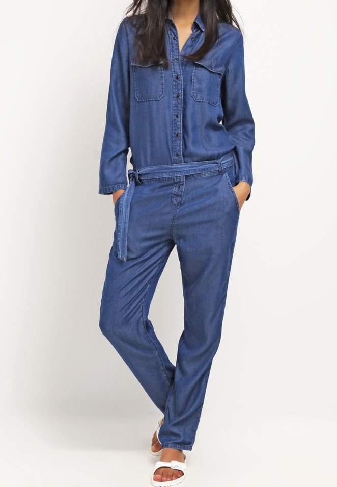 Denim overal, modrý, s dlouhými rukávy, zapínání na knoflíky v přední části, dvě náprsní kapsy, pásek v pase a volný střih. Věrný svému lehkému materiálu.