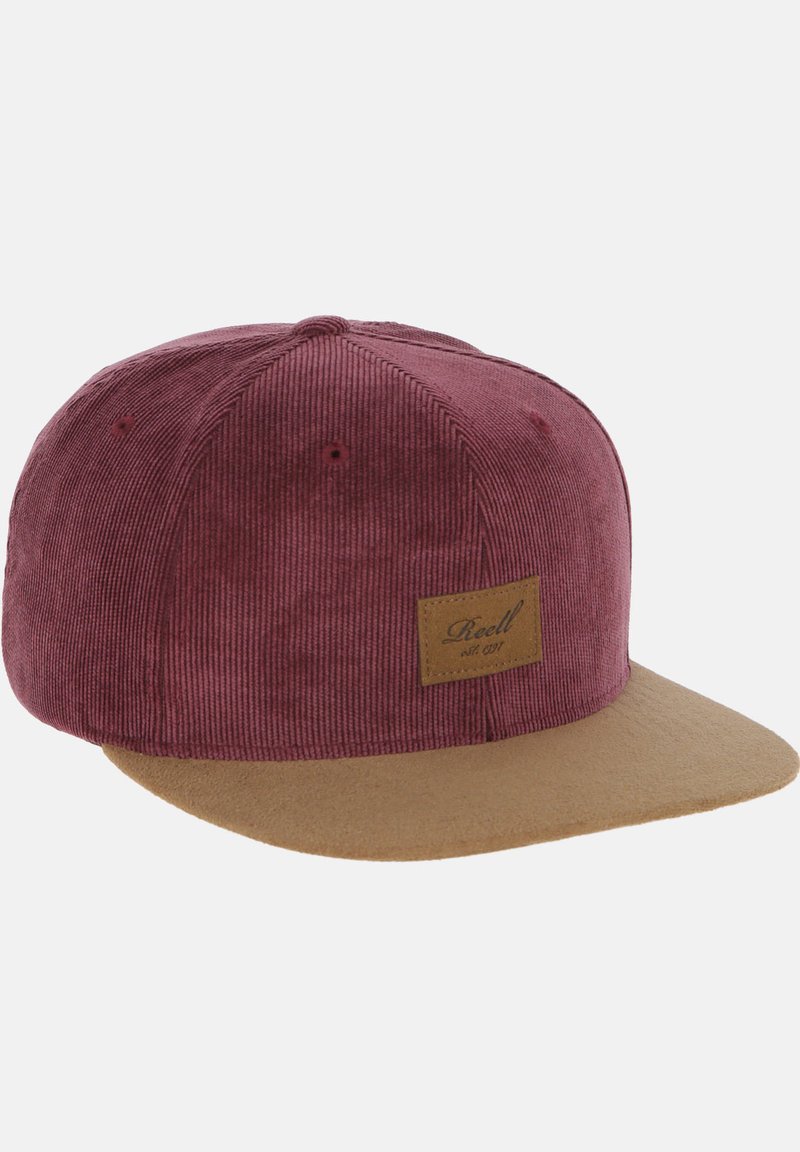 Red corduroy cap with a tan suede brim and a square leather patch featuring the brand name on the front.