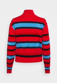 Pull en maille rayé rouge et bleu avec un col montant, des poignets ajustés et un ourlet côtelé. Présente des rayures noires alternées. Texture douce.